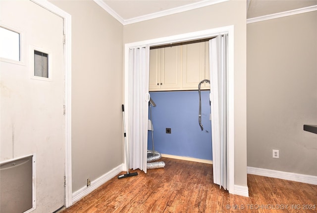 clothes washing area featuring cabinets, crown molding, and dark wood-type flooring