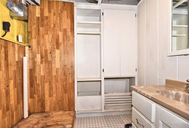 bathroom with vanity, tile patterned floors, and wood walls