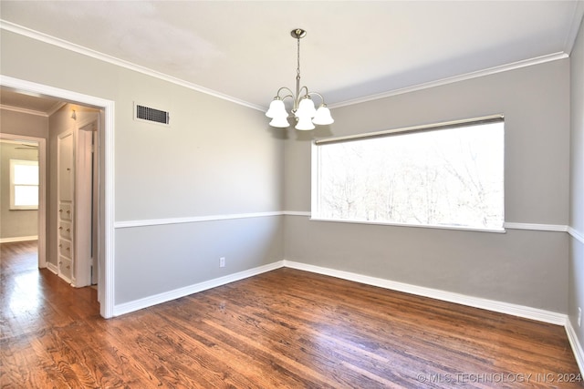 spare room featuring a chandelier, dark wood-type flooring, and ornamental molding