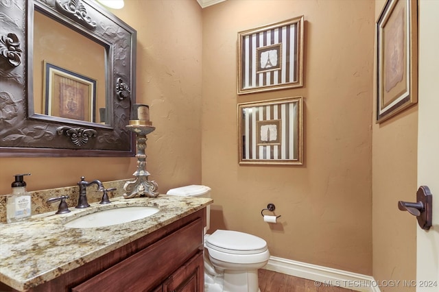 bathroom featuring wood-type flooring, vanity, and toilet