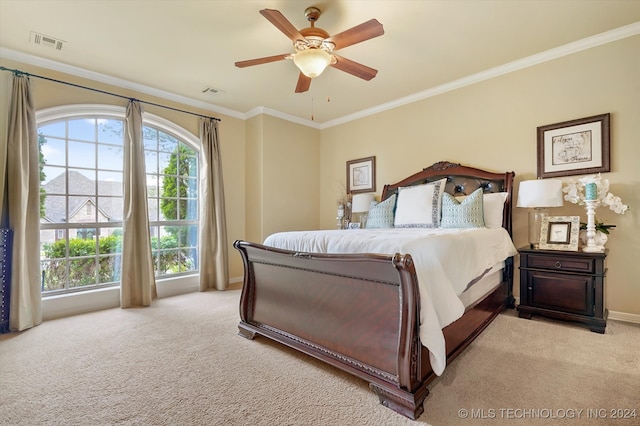 carpeted bedroom featuring ceiling fan and crown molding