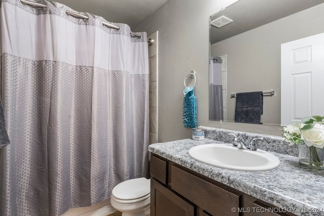 bathroom with vanity, toilet, and curtained shower