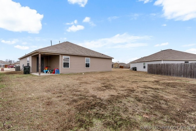 back of property with central AC, a yard, and a patio