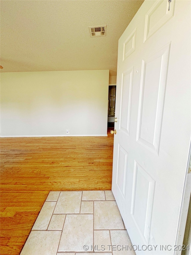 empty room featuring light hardwood / wood-style floors and a textured ceiling