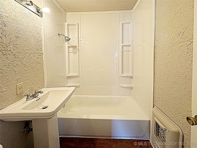 bathroom with a textured ceiling and  shower combination