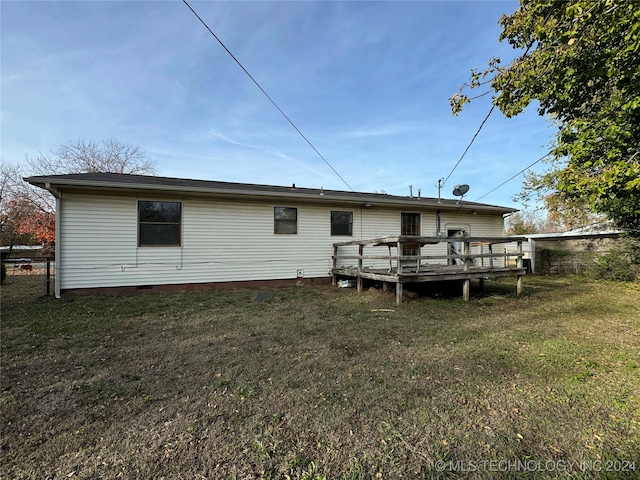 rear view of house with a deck and a lawn