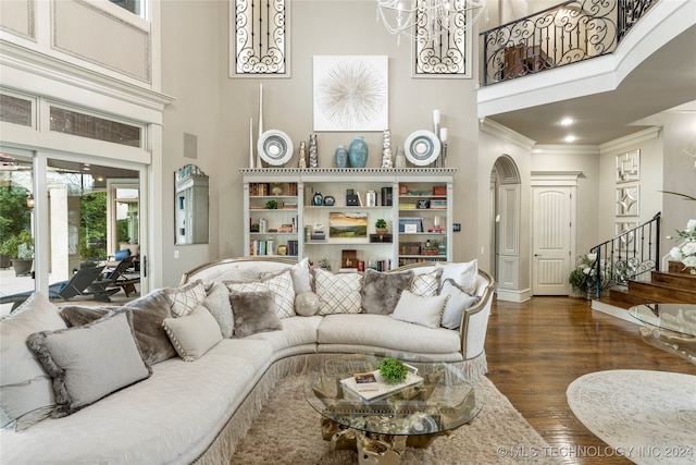 living room featuring dark hardwood / wood-style floors, a towering ceiling, and crown molding