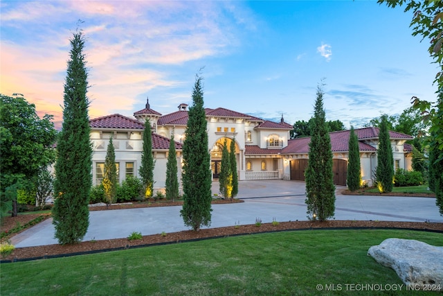 mediterranean / spanish home featuring a lawn