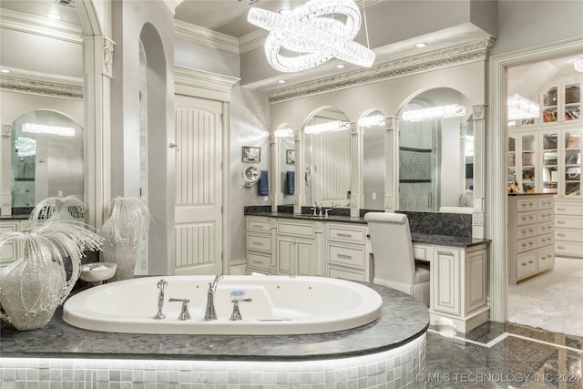 bathroom featuring tiled bath, vanity, a notable chandelier, and ornamental molding