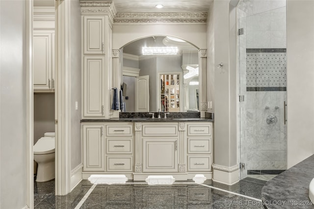 bathroom with crown molding, a shower with door, vanity, and toilet