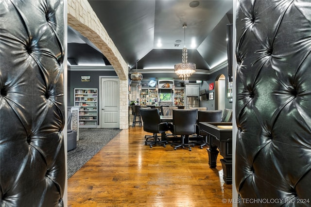 office space featuring hardwood / wood-style floors, crown molding, lofted ceiling, and a notable chandelier