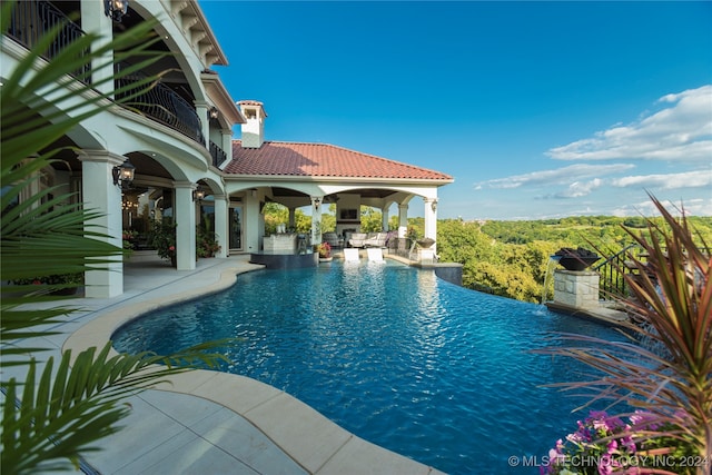 view of swimming pool with ceiling fan and a patio area