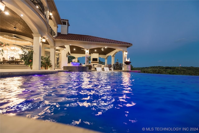 view of swimming pool with a fireplace, ceiling fan, and a patio area