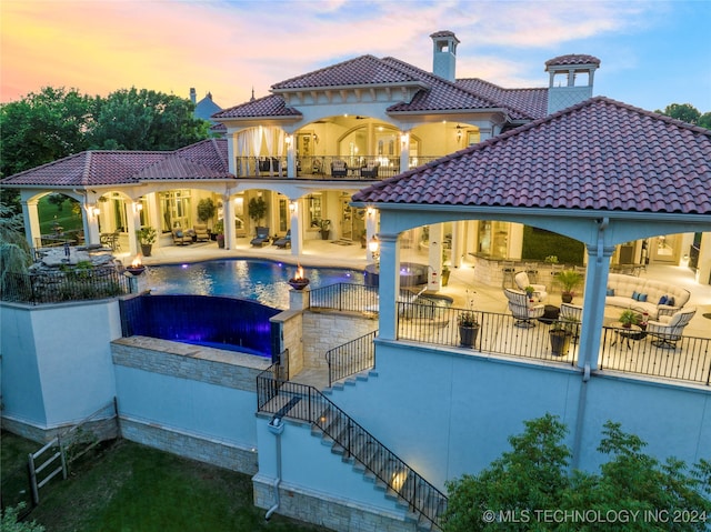 pool at dusk featuring a jacuzzi and a patio