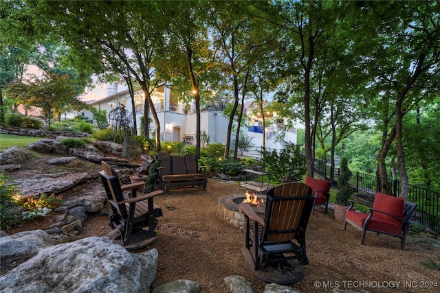 yard at dusk featuring a fire pit