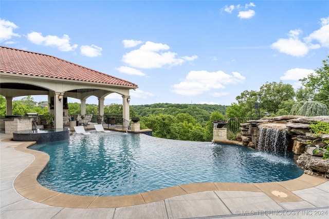 view of pool featuring pool water feature and a patio