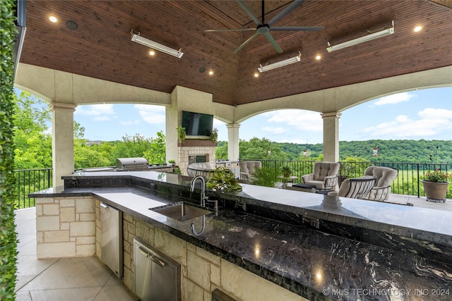 view of patio featuring ceiling fan, an outdoor hangout area, sink, and an outdoor kitchen