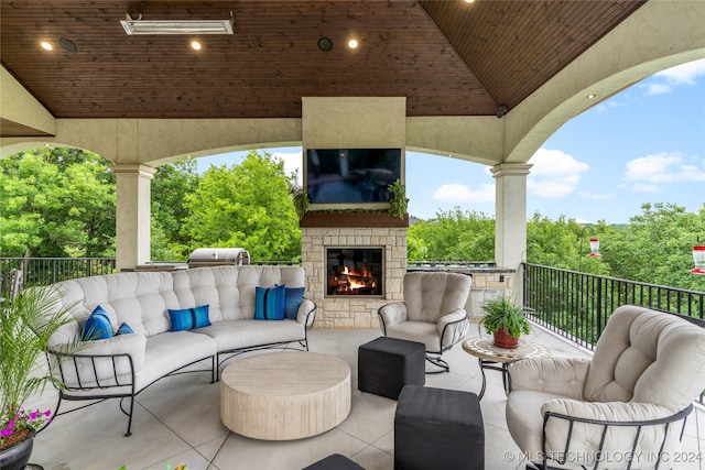 view of patio with an outdoor stone fireplace and area for grilling