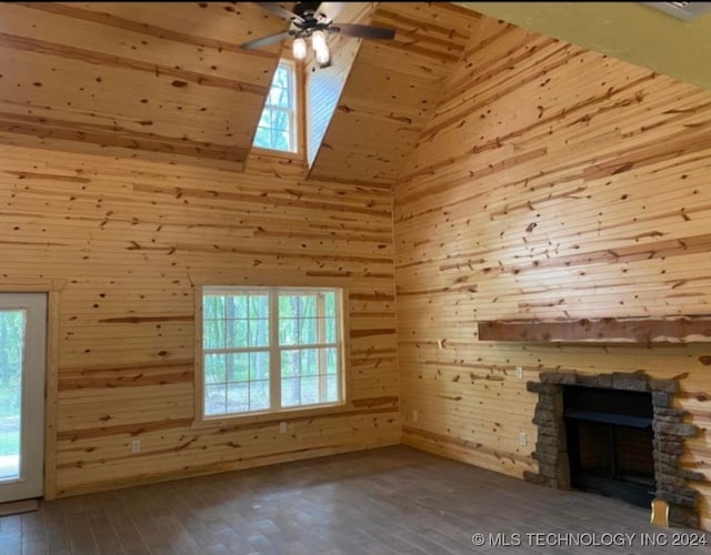 unfurnished living room featuring wooden walls, hardwood / wood-style flooring, and a healthy amount of sunlight