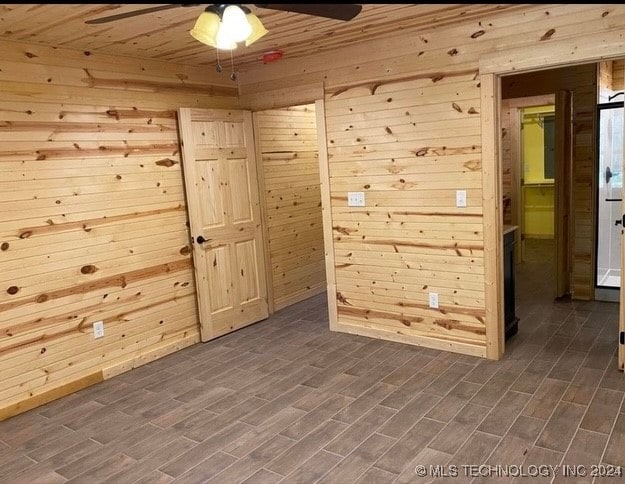 spare room featuring dark hardwood / wood-style floors, ceiling fan, wooden walls, and wood ceiling