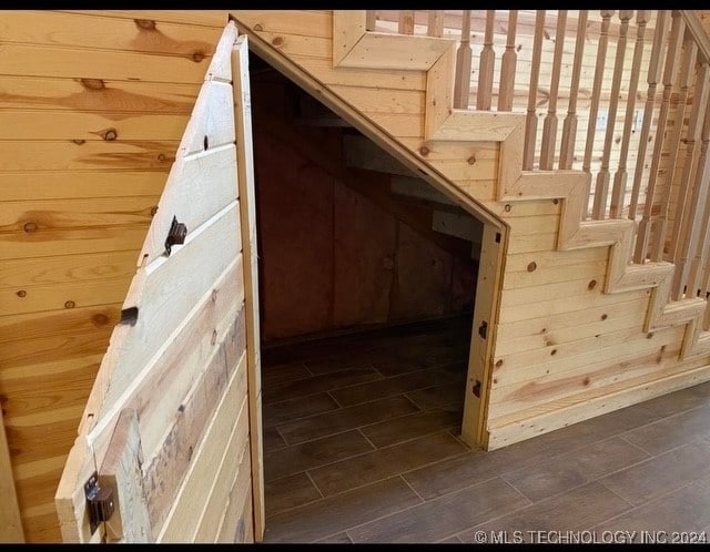 staircase featuring wooden walls