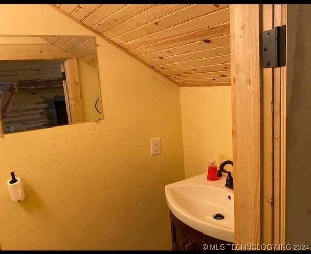 bathroom featuring wood ceiling and sink