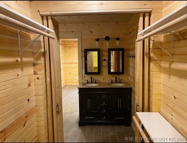 bathroom featuring hardwood / wood-style floors, vanity, and wood walls