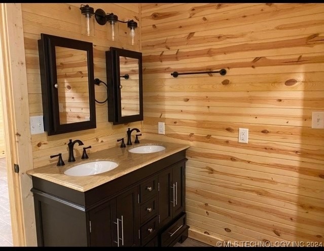 bathroom featuring vanity and wood walls