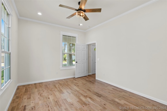 spare room featuring a healthy amount of sunlight, light hardwood / wood-style floors, and ornamental molding