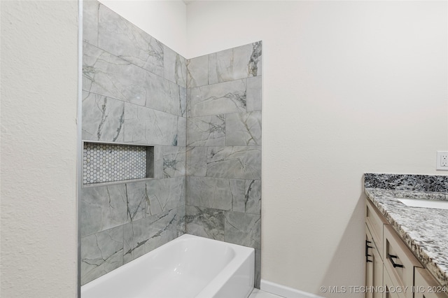 bathroom featuring vanity and tiled shower / bath