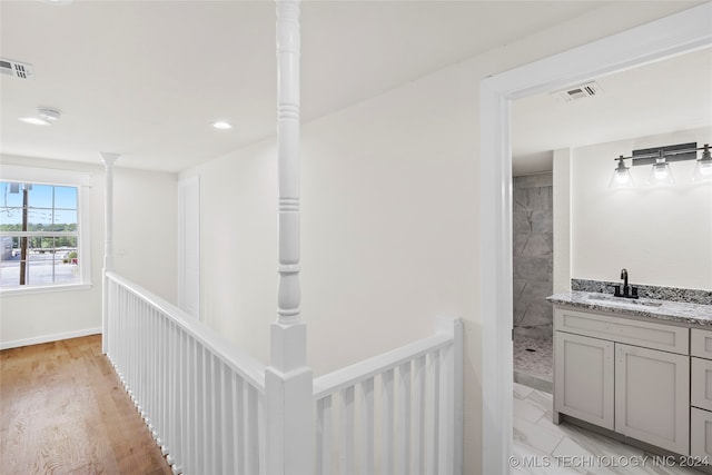 hallway with light wood-type flooring and sink