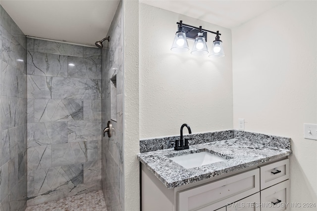 bathroom featuring vanity and tiled shower