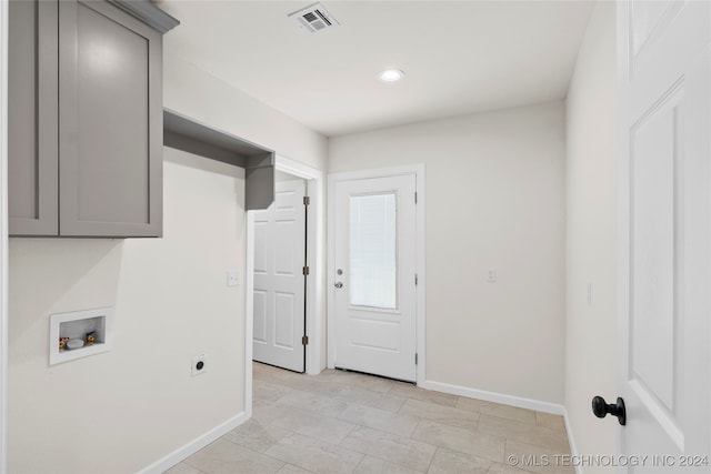 laundry area featuring electric dryer hookup, hookup for a washing machine, and cabinets