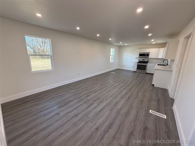 unfurnished living room with sink and dark hardwood / wood-style floors