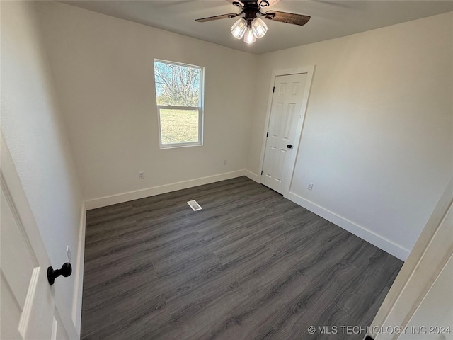 empty room featuring dark wood-type flooring and ceiling fan