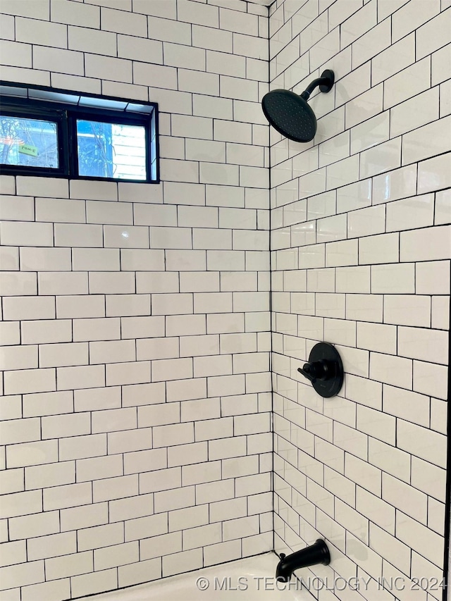 interior details featuring tiled shower / bath combo