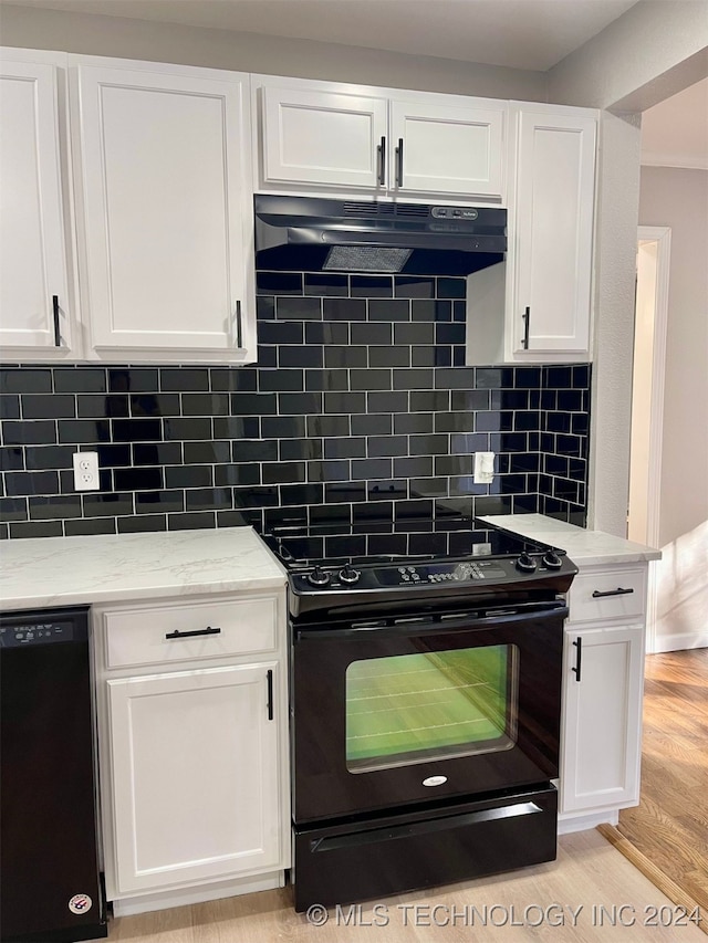 kitchen with light stone countertops, white cabinets, and black appliances