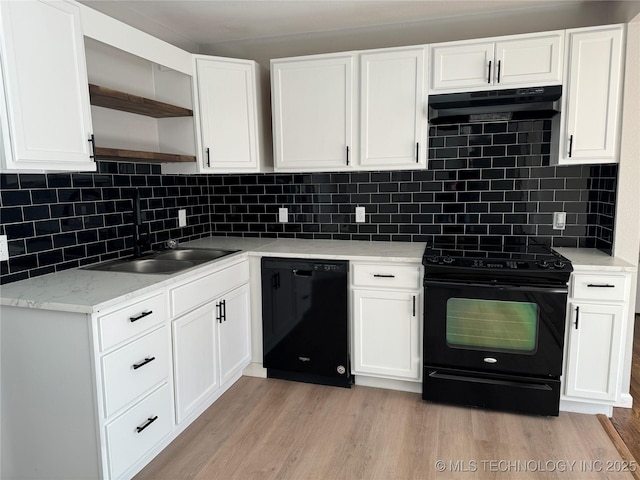 kitchen with white cabinets, backsplash, black appliances, light stone countertops, and light hardwood / wood-style flooring