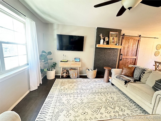 living room featuring hardwood / wood-style flooring, ceiling fan, and a barn door