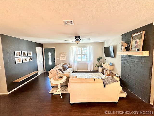 living room featuring ceiling fan, dark hardwood / wood-style flooring, and a textured ceiling