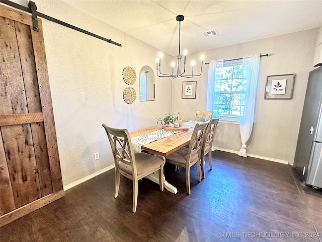 dining room featuring a barn door, dark hardwood / wood-style floors, and a notable chandelier