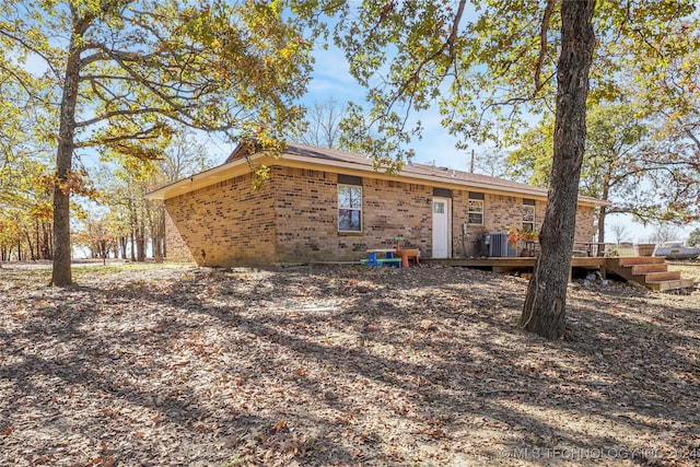 rear view of property with central air condition unit and a wooden deck