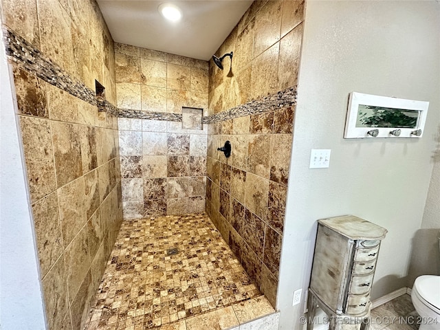 bathroom featuring a tile shower and toilet