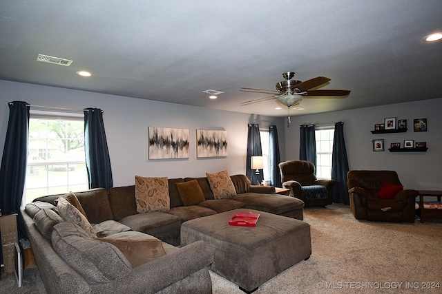 living room featuring ceiling fan, carpet, and a healthy amount of sunlight