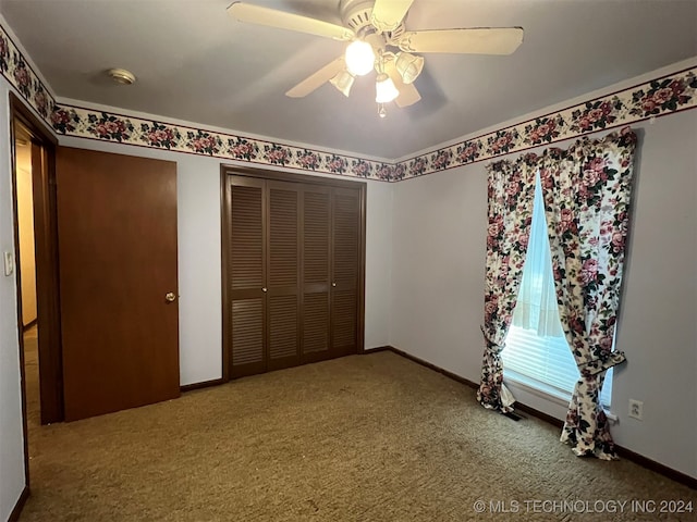 unfurnished bedroom featuring carpet flooring, a closet, and ceiling fan