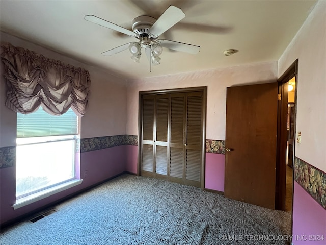 unfurnished bedroom with carpet, ceiling fan, and a closet