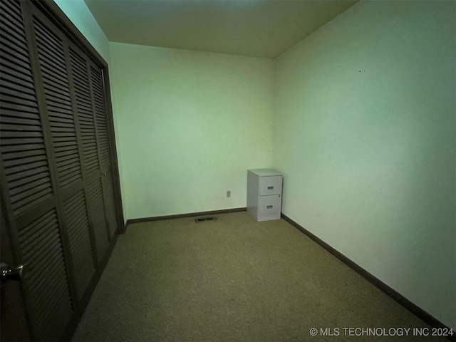 unfurnished bedroom with light colored carpet and a closet