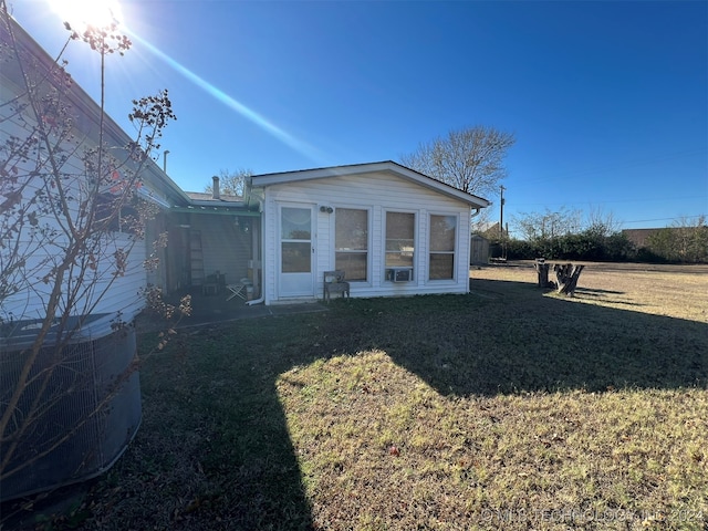 view of front of house featuring cooling unit and a front yard