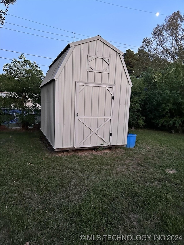 view of outbuilding featuring a lawn