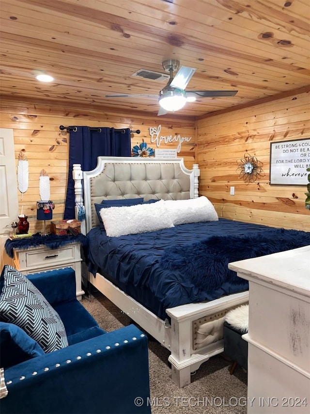 carpeted bedroom featuring ceiling fan, wood walls, and wooden ceiling